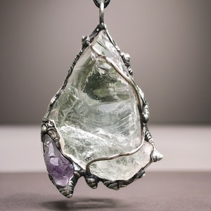 Rough Clear Quartz pendant with rainbow adorned with small Amethyst point