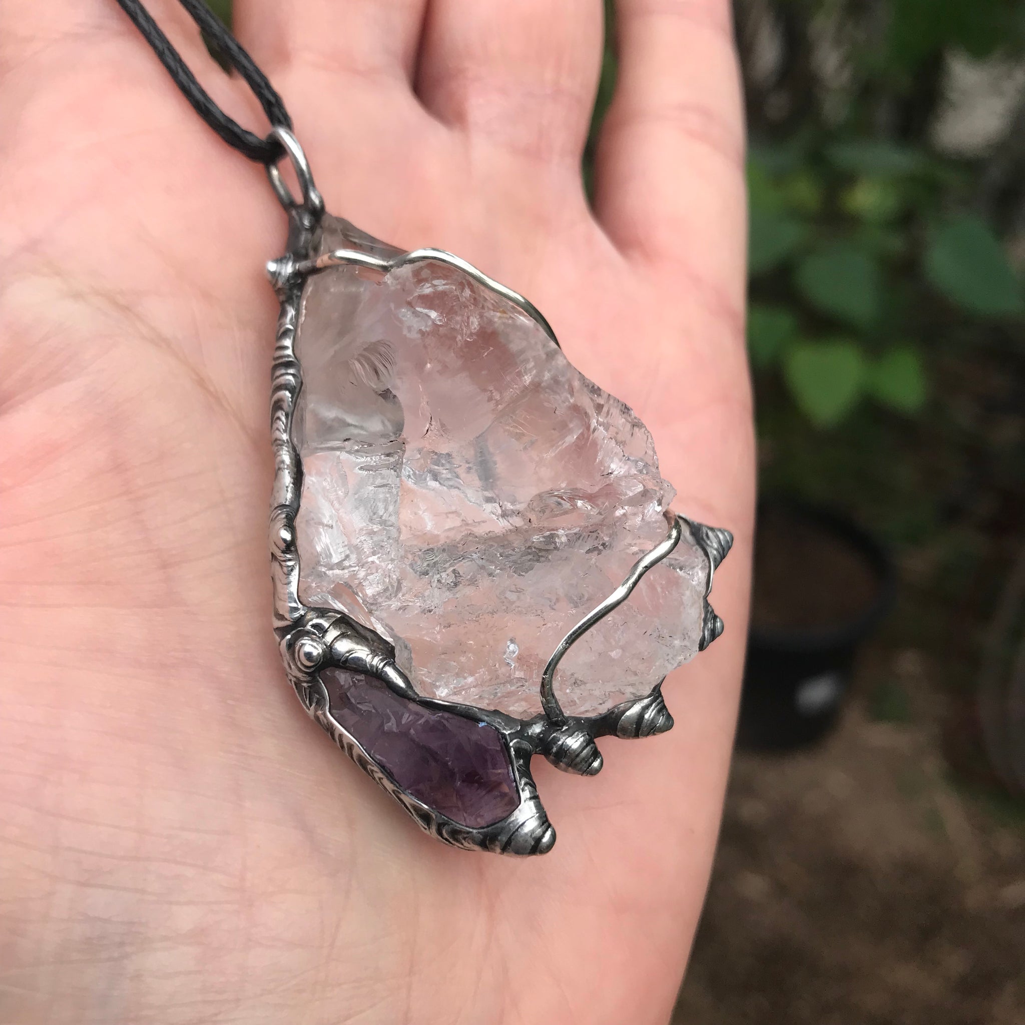 Rough Clear Quartz pendant with rainbow adorned with small Amethyst point