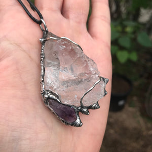 Rough Clear Quartz pendant with rainbow adorned with small Amethyst point