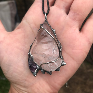 Rough Clear Quartz pendant with rainbow adorned with small Amethyst point
