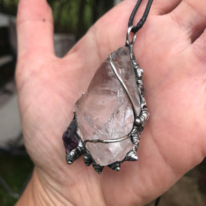 Rough Clear Quartz pendant with rainbow adorned with small Amethyst point