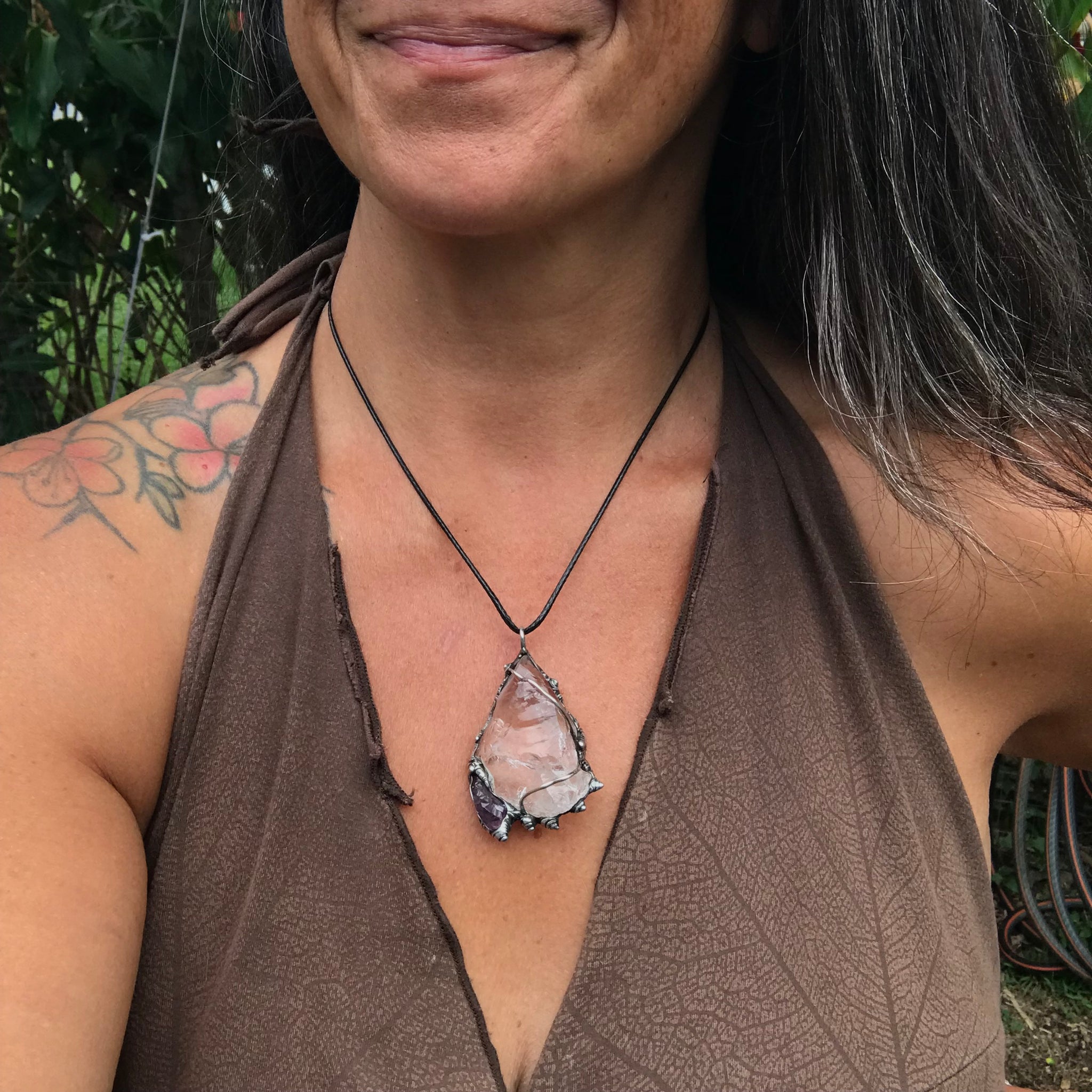Rough Clear Quartz pendant with rainbow adorned with small Amethyst point