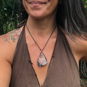 Rough Clear Quartz pendant with rainbow adorned with small Amethyst point