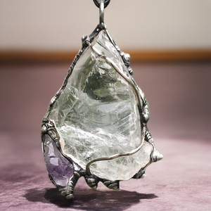 Rough Clear Quartz pendant with rainbow adorned with small Amethyst point